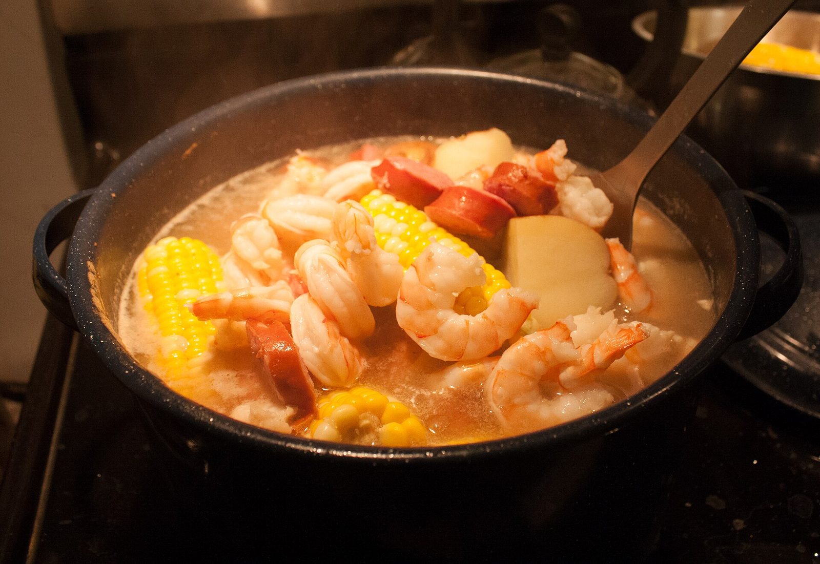 Low-country boil with wild Georgia shrimp, corn and sausage on a beachside table